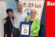 a group photograph, two woman and a man. One woman holds a framed certificate