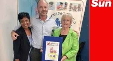 a group photograph, two woman and a man. One woman holds a framed certificate