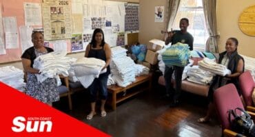 a group photograph of women holding donated linen