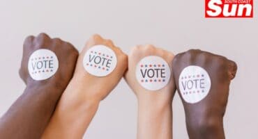 closed fists with vote stickers on them, different ethnicities