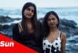 a portrait of two sisters at the beach