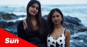 a portrait of two sisters at the beach