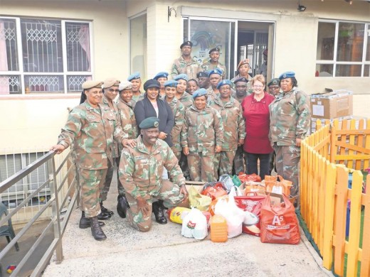 Army members hand over the food and clothing to Isaiah 54 staff.