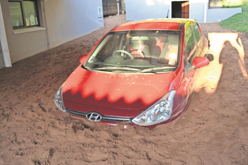 The car was almsot completely buried in the sand
