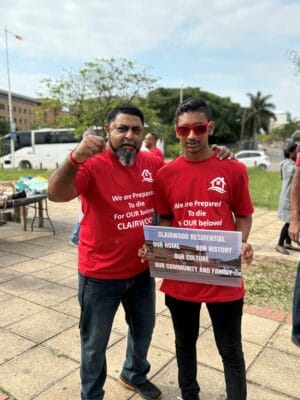 Chairperson of the Clairwood Ratepayers and Residents' Association, Mervyn Reddy and his son, Kaveeran, protest outside the Durban High Court