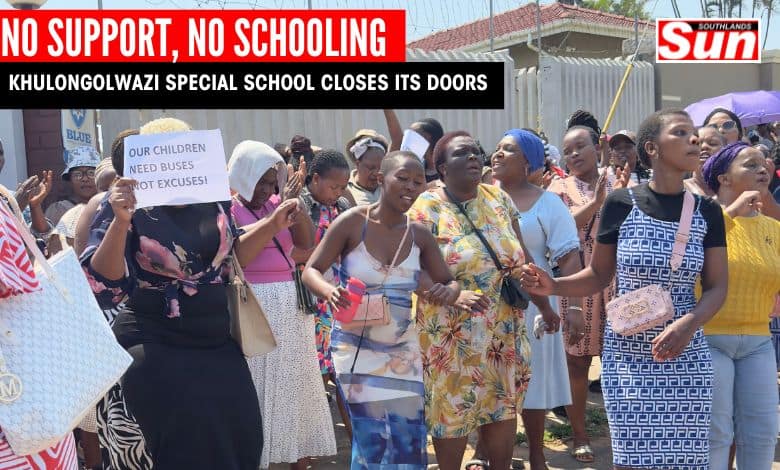 A group of women who are raising white papers with messages against the ill-treatment of the school by the Department of Education. They are also singing songs outside a locked school gate.