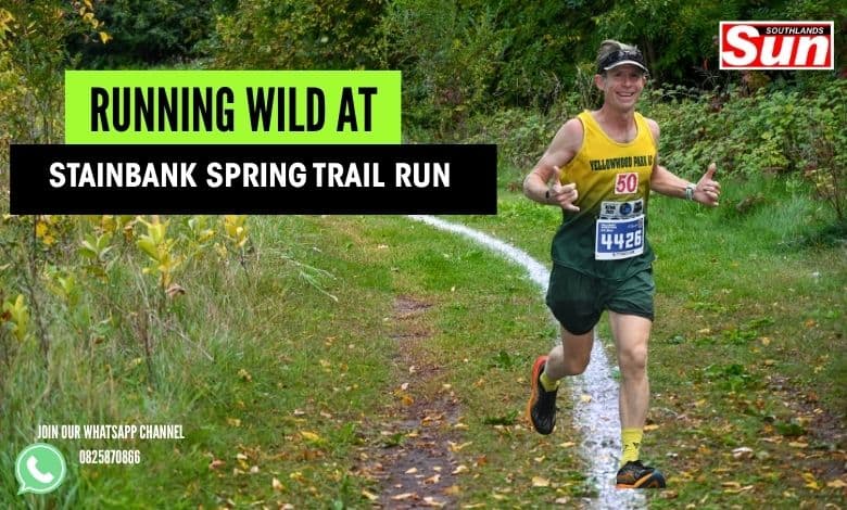 Runner celebrating as he runs through a trail.
