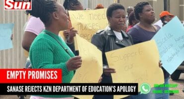 Women protesting outside the gate of a school with signs in front of them and raised. They are also saying something.