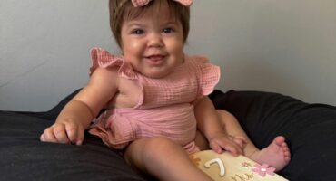 A smiling baby with a serious condition.