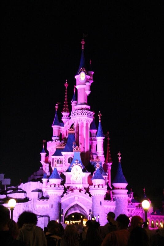 The Disney castle lit up at night.