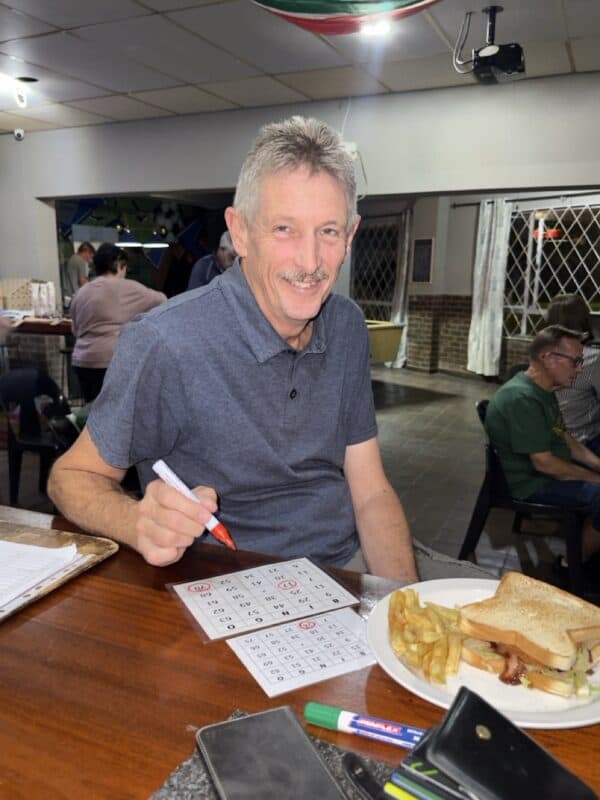 Fred Schoon enjoys his food while playing a game of bingo.