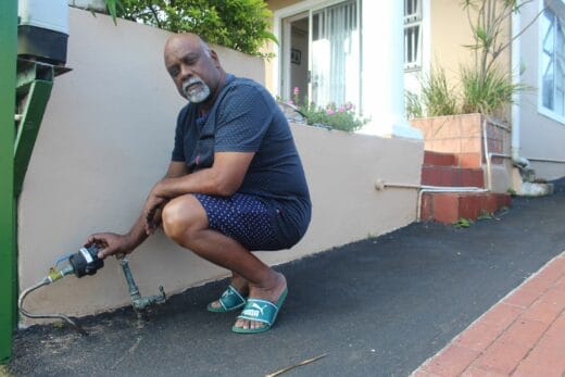 A Merebank resident, Victor Kupsamy inspects a water meter amid eThekwini Municipality's water-rollout