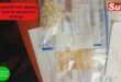 A bag of mandrax tablets and R25 cash with police documents on a table