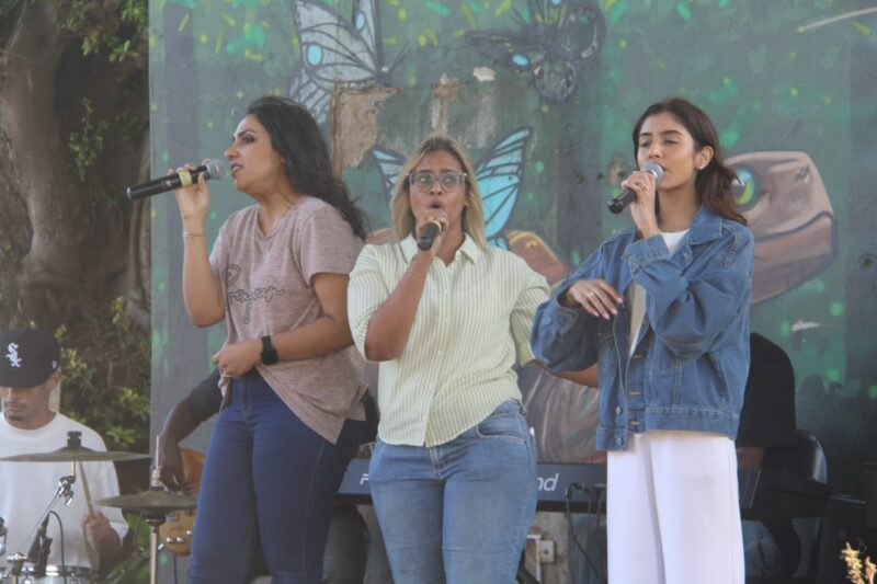 Stephanie Sam, Judith Ganess and Gillian Singh singing on stage.