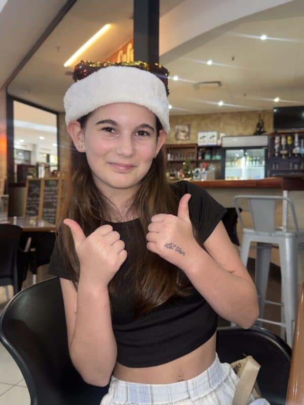 Young girl wearing Christmas hat.