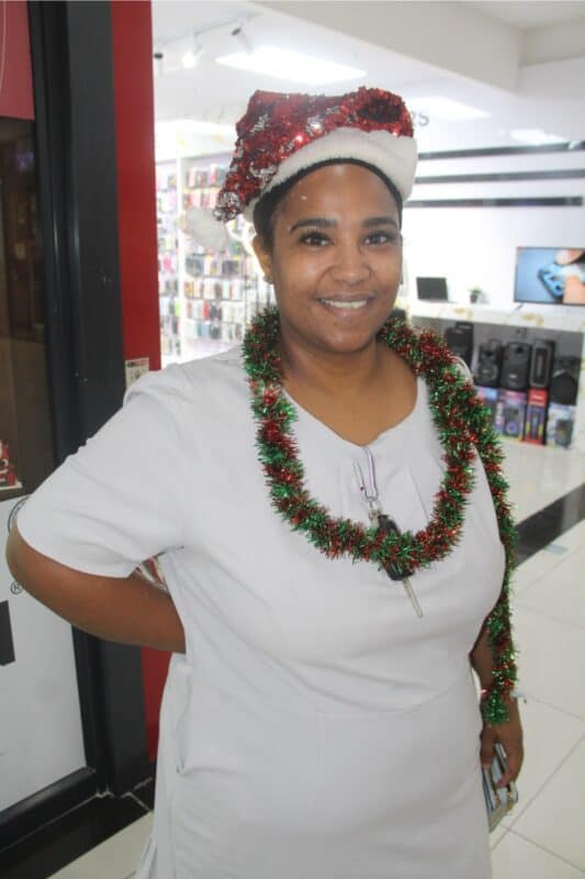 Woman dressed with tinsel and a hat.