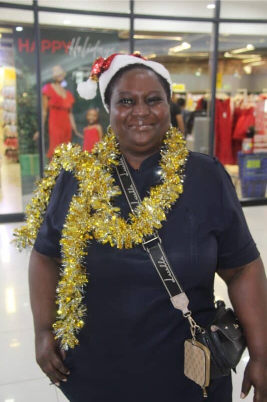 Woman dressed with tinsel and a hat.