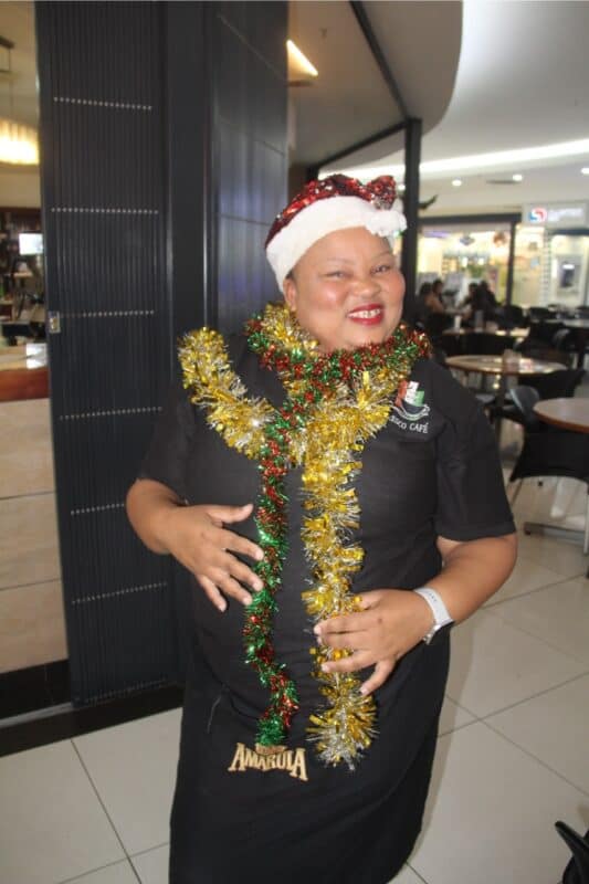 Woman dressed with tinsel and a hat.