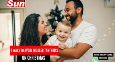 A man and woman loving embrace their toddler.