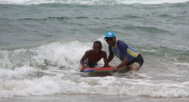Two people on a bodyboard in the surf