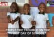 Triplets posing for their first day of school.