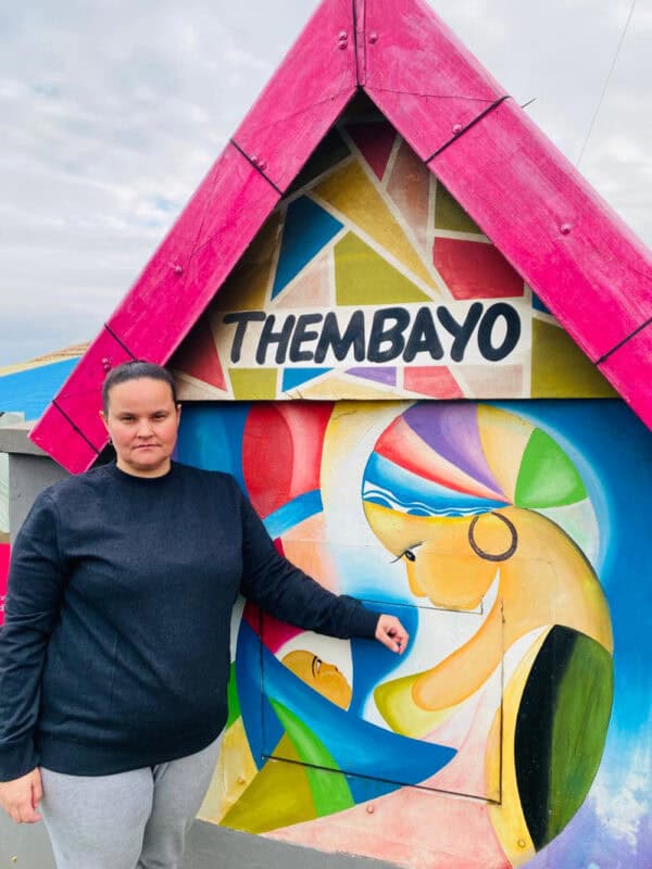 The director of the Isaiah 54 Children’s Home standing in front of their Themabyo baby saver.