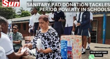 A woman hands out sanitary pads to girl learners at a school.