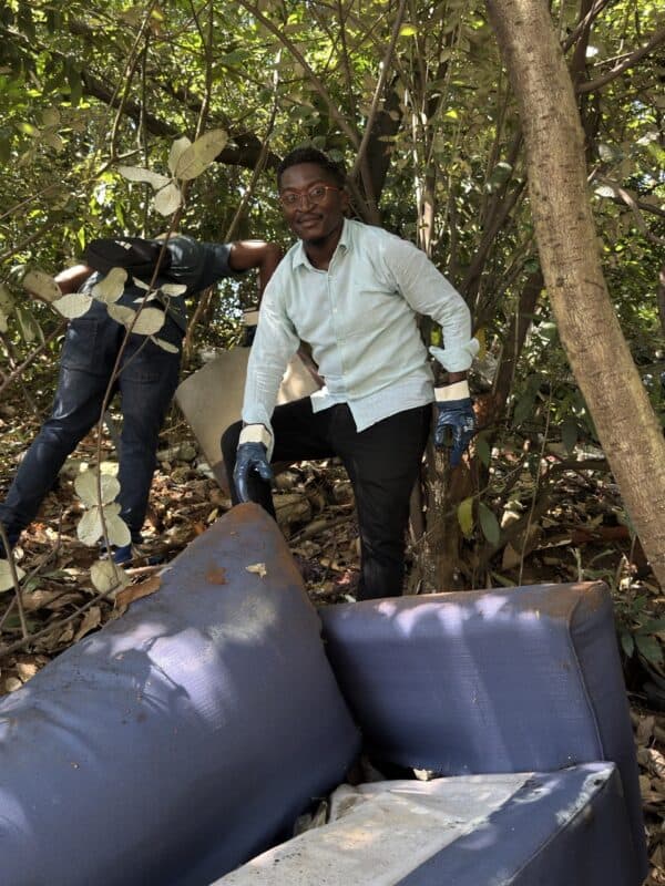 Marvin Qhobosheane from Safer Cities helps remove a couch hidden among the bushes.