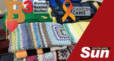 Heaps of knitted blankets on a table.