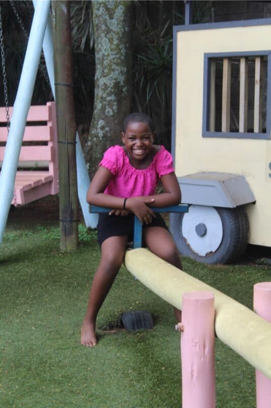Cleopatra Khuzwayo flashes a big smile while on the see saw.