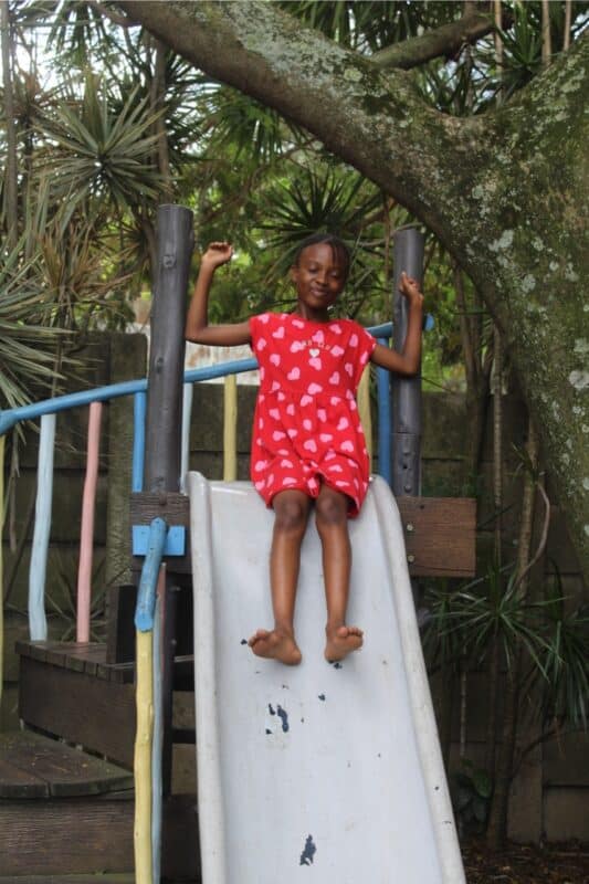 Chantal Khuzwayo lifts her hands in excitement as she makes her way down the slide.