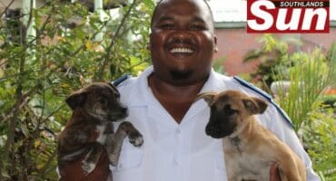 Inspector Sabelo Ngcobo of the Durban and Coast SPCA with two of six puppies rescued from a burning scrapyard in Clairwood.