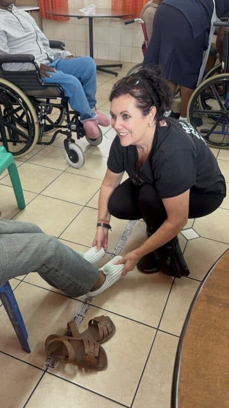 The SUN's editor Roelien D'Amico helps put on bed socks for residents at the Merewent Cheshire Home.