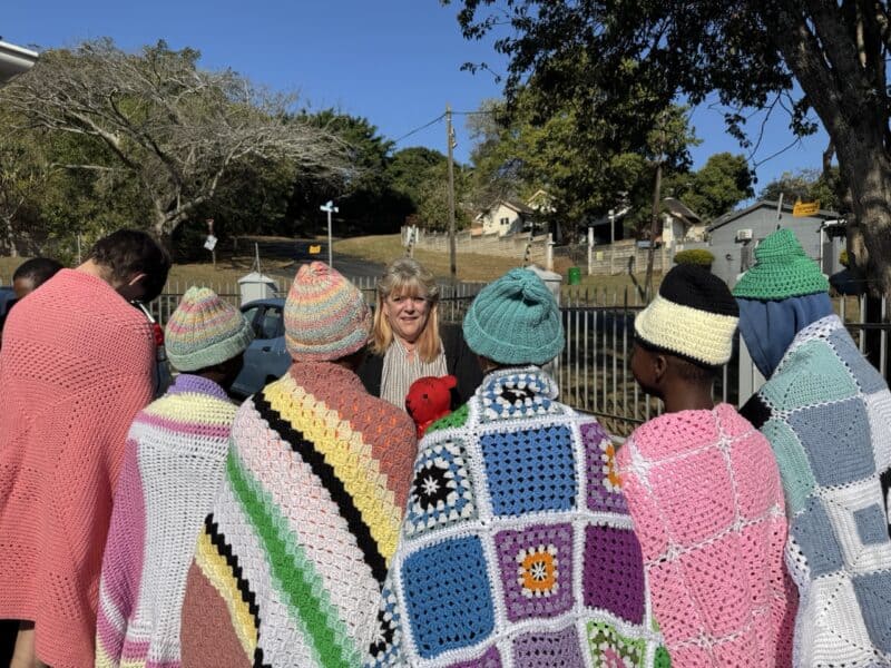 Eureka Olivier of Bobbi Bear with some of the children showing off their colourful blankets.