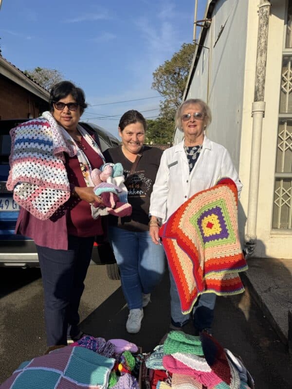 Kingsburgh Welfare Centre's Sandra Govender and Jenny Smith accept their donation of blankets, beanies and booties from the SUN's Gerda MacGregor.