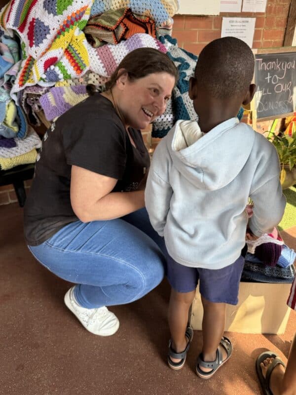 The SUN's Gerda MacGregor helps one of the children at St Monica's Children's Home to pick a blanket and beanie.