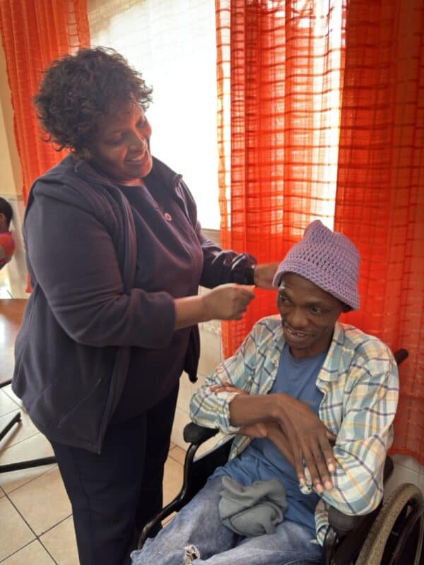 Caregiver at the Merewent Cheshire Home Fikile Dlamini helps out resident Malibongwe Macingwane.