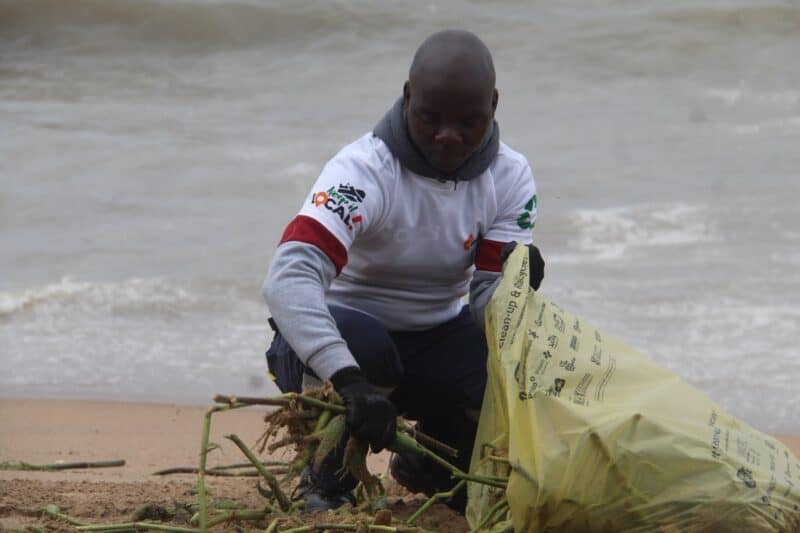 Bongumusa Vezi packs collected dirt in the bin.