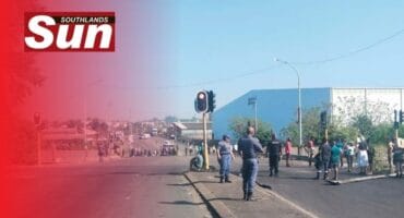 A group of angry protesters and police standing in the road