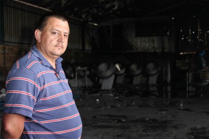 Production Manager, Willem du Preez stands in the door way of the guttered warehouse.