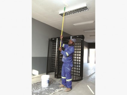A worker paints the ceiling near the turnstile entrance way to the swimming pool area at Van Riebeeck Park.