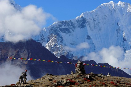 The rhino climbers passing Nepali prayer flags en route to Mera Peak. Photo: Provided by Wayne Matthew
