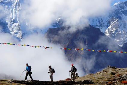 The rhino climbers passing Nepali prayer flags en route to Mera Peak. Photo: Provided by Wayne Matthew