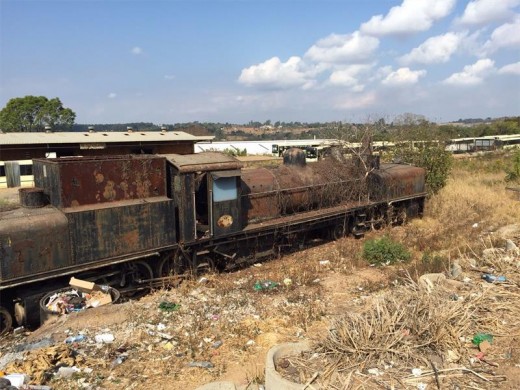The locomotive was overrun with weeds and rust.