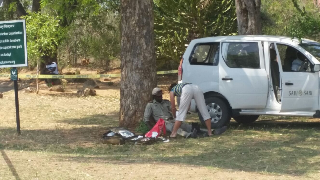 'n Onbekende vrou op die toneel sien om na een van die gewonde mans.