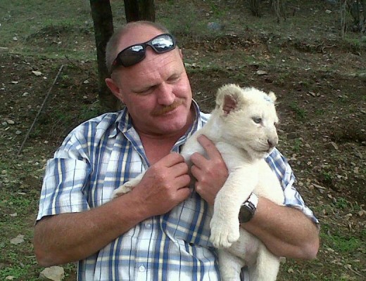 Die Kaptein deel 'n ligte oomblik met 'n wit leeutjie. Hy is baie lief vir diere en sien die beskerming van alle lewende dinge as sy mandaat. (Foto: Facebook.)