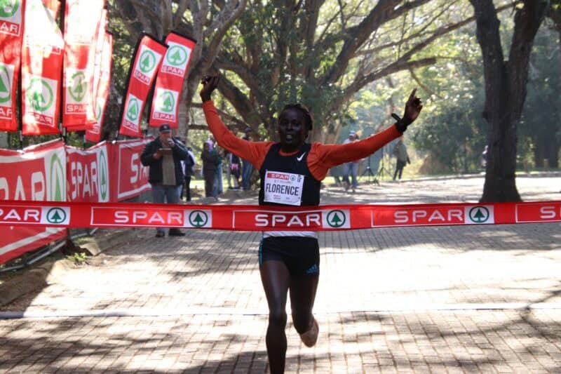 Florence Nyaingiri crosses the finish line in first place. > Photo: Blake Linder