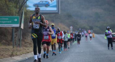 Runners make their way down the hill on the R40 before reaching the Riverside district. > Photo: Blake Linder
