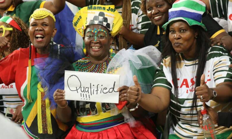 Mama Joy Chauke (middle) along with other supporters celebrate Bafana Bafana's qualification for the FIFA World Cup. > Photo: Blake Linder