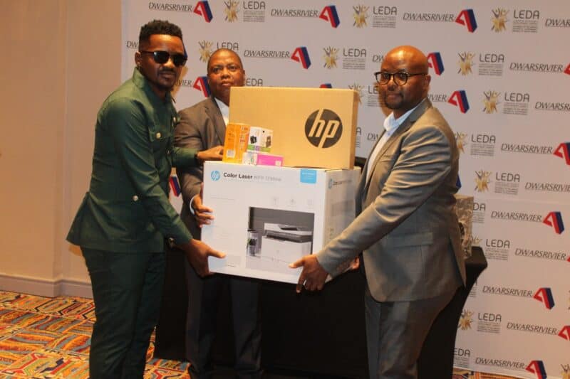 Entrepreneur Kenny Masha holds his certificate, flanked by DCM and LEDA management.